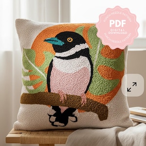May include: A square, beige throw pillow with a punch needle design featuring a colorful bird perched on a branch. The bird has a black head, white chest, pink belly, and blue beak. The background includes orange and green foliage. The text "PUNCH NEEDLE PATTERN PDF DIGITAL DOWNLOAD" is visible.