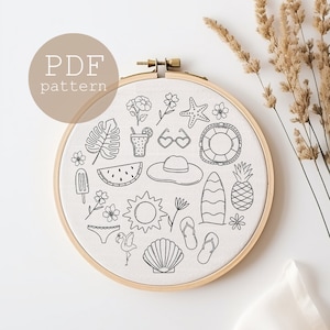 Könnte beinhalten: Ein weißer Stickrahmen mit einer Schwarzweiß-Zeichnung verschiedener sommerlicher Symbole, darunter eine Wassermelone, Sonnenbrillen, eine Ananas, ein Surfbrett, eine Muschel, ein Flamingo und eine Sonne. Der Text "PDF pattern" ist in Braun auf braunem Hintergrund geschrieben.