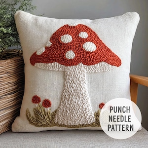 Könnte beinhalten: Ein weißes Kissen mit einem roten und weißen Pilzdesign. Der Pilz ist mit einer Punch-Needle-Stickerei gefertigt. Das Kissen trägt den Text "Punch Needle Pattern".