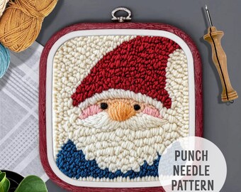 Op de afbeelding: Een punch needle patroon met een roodmutsdragende gnome met een witte baard en blauwe kleding. Het patroon is ingelijst in een rode houten ring met een witte achtergrond. De tekst "Punch Needle Pattern" is onder de ring gedrukt.