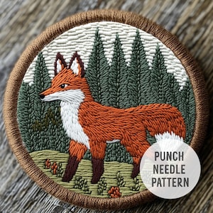 May include: A punch needle pattern featuring a fox in a forest setting. The fox is orange with white accents and is standing in front of a row of green trees. The pattern is surrounded by a brown circle with the text "Punch Needle Pattern" in white.