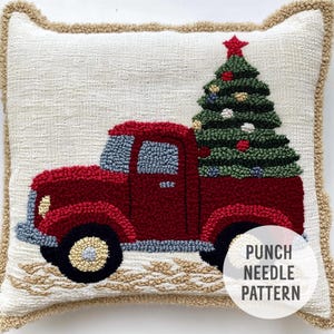 May include: Punch needle pattern featuring a red truck carrying a green Christmas tree with ornaments and a star on top. The text "PUNCH NEEDLE PATTERN" is in the lower right corner of the image.