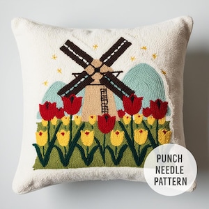 May include: A white pillow with a punch needle design of a windmill and tulips. The windmill is brown and has a blue sky behind it. The tulips are red and yellow. The text "PUNCH NEEDLE PATTERN" is in the lower right corner of the pillow.