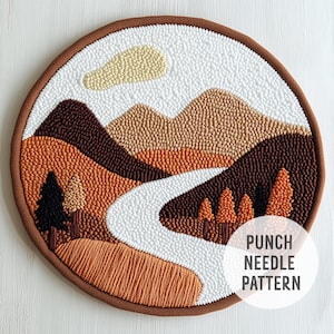 Könnte beinhalten: Punch-Needle-Muster einer Landschaft mit Bergen, einem Fluss und Bäumen in Braun-, Orange- und Weißtönen. Das Muster befindet sich auf einem braunen Stoffhintergrund. Der Text "Punch Needle Pattern" befindet sich in der unteren rechten Ecke.