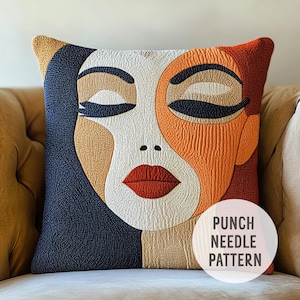 Op de afbeelding: Een punch needle borduurpatroon met een gestileerd gezicht met gesloten ogen, een rode mond en een mix van oranje, bruin en blauwe kleuren. Het patroon is gelabeld "Punch Needle Pattern".