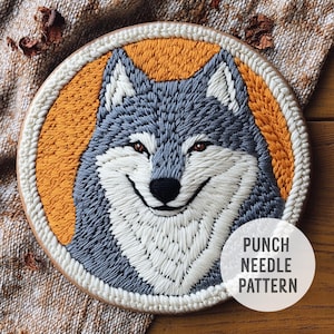 May include: A punch needle pattern featuring a grey and white wolf with a smiling expression. The wolf is embroidered on a yellow background. The text "PUNCH NEEDLE PATTERN" is visible in the bottom right corner of the image.