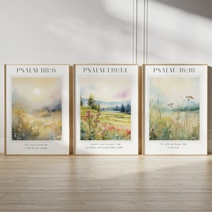 May include: Three watercolour paintings with inspirational bible verses from Psalms. The first painting depicts a field with a sun rising in the distance. The second painting shows a field with a forest in the background. The third painting shows a field with tall grass and flowers. The text on the paintings reads "PSALM 118:6", "PSALM 139:14", and "PSALM 46:10".