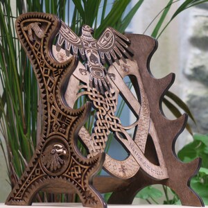 May include: A wooden stand with a Native American design featuring a stylised eagle and intricate patterns. The stand is made of dark wood and has a cutout design. The text "Native American" is engraved on the stand.