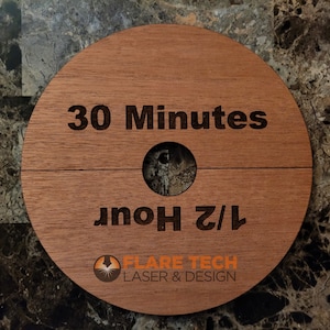 Peut inclure: Une enseigne ronde en bois avec le texte "30 Minutes" et "1/2 Heure" grav&eacute; dessus. L'enseigne pr&eacute;sente &eacute;galement le logo de "Flare Tech Laser & Design".