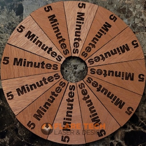 Peut inclure: Une roue en bois avec 12 sections, chacune &eacute;tiquet&eacute;e "5 Minutes". La roue est en bois brun clair et fonc&eacute; et a un trou au centre.