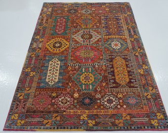 Könnte beinhalten: Ein rechteckiger Teppich mit einem Patchwork-Design. Der Teppich weist verschiedene geometrische Muster in Rot-, Blau-, Gelb- und Brauntönen auf. Der Rand ist dunkler Rot, und das Gesamtdesign ist komplex und detailliert.