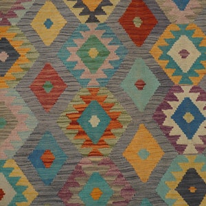May include: A colorful rug with a geometric pattern in shades of blue, red, orange, yellow, green, and purple. The rug has a diamond-shaped design with intricate details.