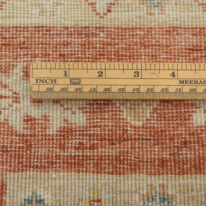 May include: Close-up of a wooden ruler measuring 6 inches, with markings in inches and centimeters. The ruler is placed on top of a red and white patterned rug.