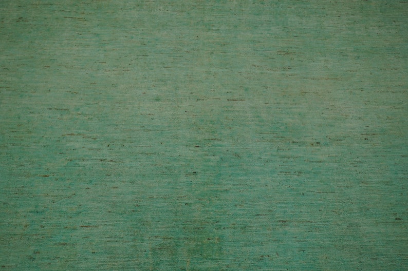 May include: A close-up of a textured green surface with a subtle wood grain pattern.