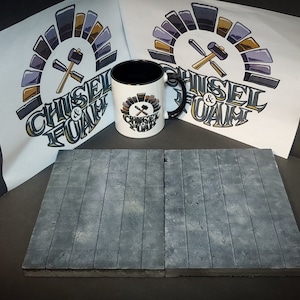 May include: Two gray foam floor tiles with a wood plank design. The tiles are next to each other on a dark surface. A white mug with a black rim and a black handle is in the center of the image. The mug has a logo on it that says "Chisel & Foam" with a crossed hammer and chisel. There are two white sheets of paper with the same logo on them in the background.