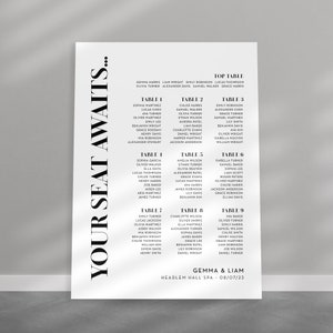 May include: A black and white wedding seating chart with the text "Your Seat Awaits..." in bold, black letters. The chart lists the names of guests assigned to different tables, including a "Top Table" with the names Gemma and Liam. The date of the wedding is listed as 08/07/23.