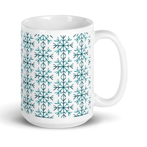 May include: White ceramic mug with a teal and dark blue snowflake pattern.
