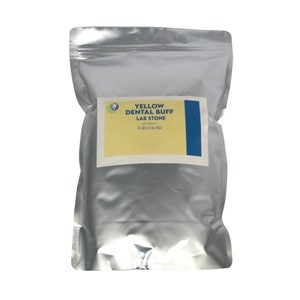 May include: A silver bag with a yellow label that says "YELLOW DENTAL BUFF LAB STONE" and "NET WEIGHT: 3 LBS (1.36 KG)".