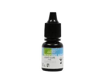 May include: A small, black bottle with a black cap. The bottle has a white label with the words "BONDING ADHESIVE LIGHT CURE 7 ml" in green and blue. The bottle is against a white background.