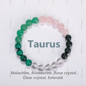 May include: A bracelet made of green malachite, aventurine, rose quartz, clear quartz, and emerald beads. The bracelet is labeled "Taurus" and lists the stones used: Malachite, Aventurine, Rose crystal, Clear crystal, Emerald.