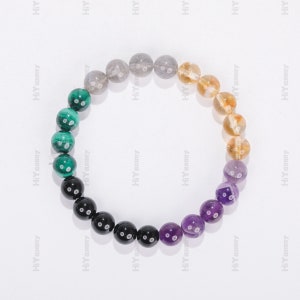 May include: A multi-colored beaded bracelet with green, black, purple, yellow, and gray beads.