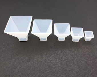 May include: Set of six white silicone pyramid-shaped molds of varying sizes.