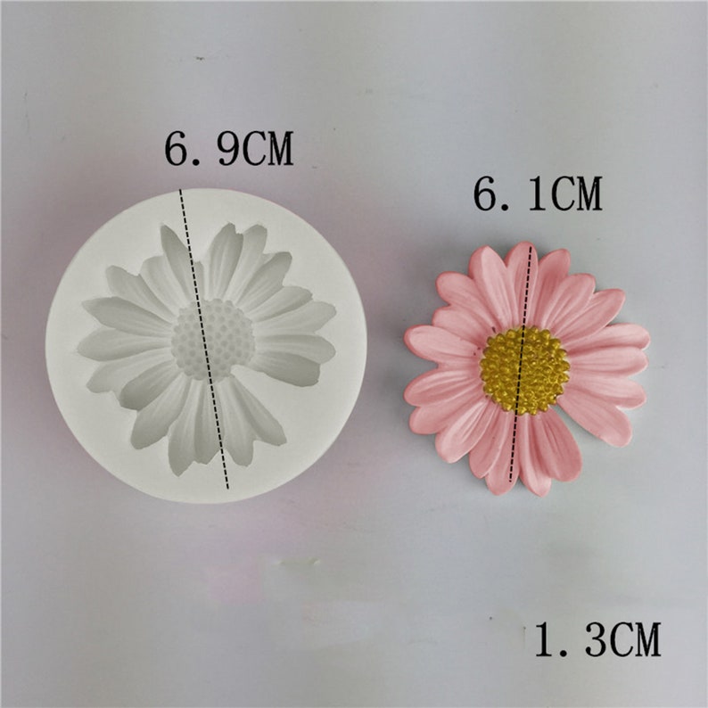 May include: A silicone mould for making daisy-shaped decorations. The mould is 6.9 cm in diameter and the daisy is 6.1 cm wide.