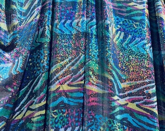 May include: Close-up of a fabric with a vibrant, iridescent animal print. The design features zebra stripes, leopard spots, and abstract shapes in shades of blue, green, purple, and yellow. The fabric has a shimmering, textured appearance.