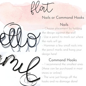 May include: Black metal wire word art spelling "hello" and "smile" with instructions for hanging using nails or command hooks. The background features a watercolor wash in pink.