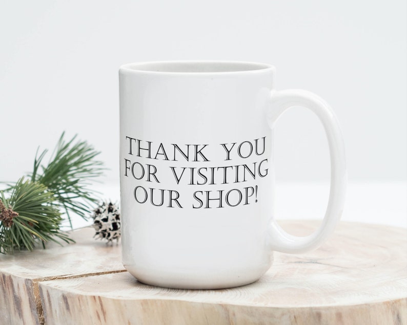May include: White ceramic coffee mug with black text that reads "Thank you for visiting our shop!"