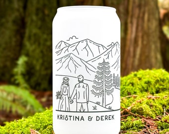 May include: White aluminum can with a black line drawing of a mountain landscape, two people holding hands, and the text "KRISTINA & DEREK".