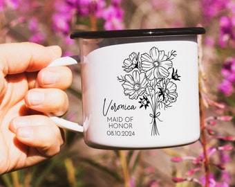 May include: White enamel mug with a black rim and handle. The mug has a black and white illustration of a bouquet of flowers and the text "Veronica Maid of Honor 08.10.2024".