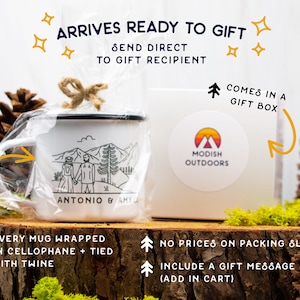 May include: A white enamel mug with a black rim and handle. The mug has a black and white illustration of a couple standing in front of mountains with the text "Antonio & Amy". The mug is wrapped in cellophane and tied with twine. The mug is in a white gift box with a sticker that says "Modish Outdoors".