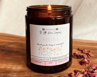 May include: A brown glass candle jar with a white label that reads "The Little Peace Company" and "MUM Thank you for being so wonderful!" The candle is soy wax and has a floral aroma of rose geranium, lavender, and frankincense essential oils. The candle is 180ml and has a burn time of 30 hours.