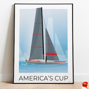 Può includere: Un poster incorniciato in nero con un'illustrazione minimalista di una barca a vela con vele rosse e grigie. Il testo "AMERICA'S CUP" è stampato in nero nella parte inferiore del poster.