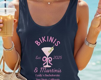 May include: Navy blue tank top with the words "Bikinis & Martinis" in pink, along with a martini glass graphic. The text "Emily's Bachelorette, San Diego, California" is also printed on the shirt.