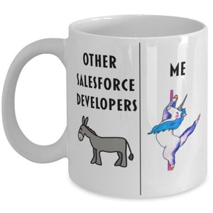 May include: White coffee mug with black text that reads "Other Salesforce Developers" and a cartoon donkey on the left side. The right side of the mug reads "Me" and features a cartoon unicorn doing a pole dance.