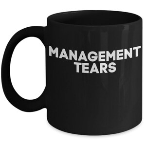 May include: Black coffee mug with white text that reads "MANAGEMENT TEARS".