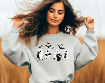 Könnte beinhalten: Ein hellgraues Sweatshirt mit einem Halloween-Design. Das Design zeigt vier Cartoon-Geister, eine schwarze Katze und mehrere Fledermäuse. Die Geister haben verschiedene Ausdrücke und Posen. Fledermäuse fliegen über den Geistern.