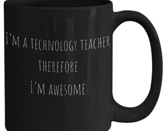 May include: A black ceramic mug with a handle on the right side. The front of the mug features white text that reads: I'M A TECHNOLOGY TEACHER THEREFORE I'M AWESOME. The mug has a smooth, matte finish and a standard cylindrical shape for holding beverages.