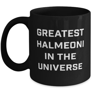 May include: Black coffee mug with white text that reads "Greatest Halmeoni in the Universe".
