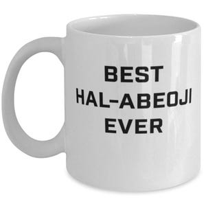 May include: A white ceramic mug with a C-shaped handle featuring the black printed text BEST HAL-ABEOJI EVER centred on the front. The mug has a smooth, glossy finish and a standard cylindrical shape with a flat base and a wide rim.