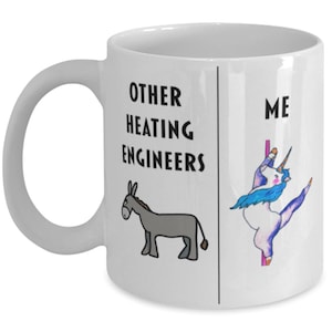 Op de afbeelding: Een witte keramische koffiemok met een zwart-witte illustratie van een ezel aan de linkerkant en een eenhoorn aan de rechterkant. De tekst "Other Heating Engineers" staat boven de ezel en "Me" staat boven de eenhoorn.