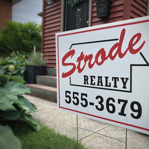 以下が含まれることがあります： 赤と黒の文字で書かれた白い不動産看板。看板には「Strode Realty」と「555-3679」と書かれている。