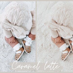 May include: A baby wearing a striped hat and matching outfit, sitting on a white fluffy rug. The baby is wearing white socks with ruffles and brown sandals.