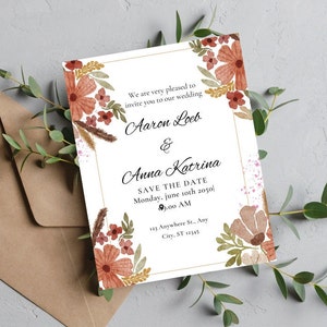 May include: Wedding invitation with floral watercolor design. The invitation features the names "Aaron Loeb & Anna Katrina" and "Save the Date" details. The invitation is surrounded by brown and green floral elements and a brown envelope.