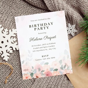 May include: A birthday party invitation with floral accents. The invitation reads "You are invited to the BIRTHDAY PARTY honoring Helene Paquet." Details include the date, time, location, and RSVP information. The invitation is on a gray knitted surface.