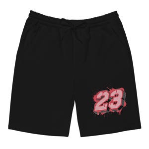 May include: Black shorts with a drawstring waist and pockets. The shorts feature a red and white number "23" graphic with a splatter design. The shorts are made of a soft material.