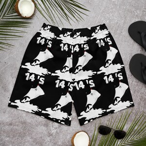 May include: Black and white patterned men's swim trunks with the text "14's" repeated throughout the design. The trunks have a drawstring waist and a relaxed fit.
