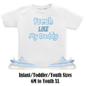 May include: White t-shirt with blue text that reads "Fresh Like My Daddy". A pair of light blue and white trainers are below the shirt. The text "Infant/Toddler/Youth Sizes 6M to Youth XL" is below the trainers.